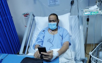 رغم المرض معلم بتعليم صبيا يشرح الدروس لطلابه عن بعد وهو على السرير الأبيض