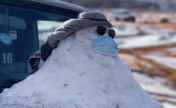 مرتديًا كمامة .. بالصور: مواطن يظهر ابداعاته ويبني رجل الثلج في علقان