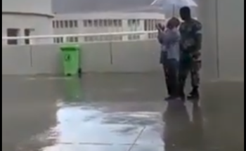 شاهد.. رجل أمن يحمل مظلة لأحد الحجاج أثناء قيامه بالدعاء لحمايته من المطر