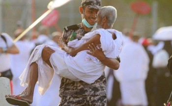 صورة لرجل أمن يبتسم وهو يحمل حاجا نال منه التعب يخطف الأنظار