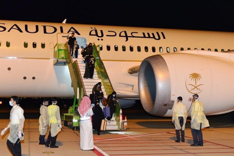 “قبلة جواز السفر وارتداء وشاح الوطن” .. شاهد: أول صور للمواطنين القادمين من مدريد إلى مطار حائل