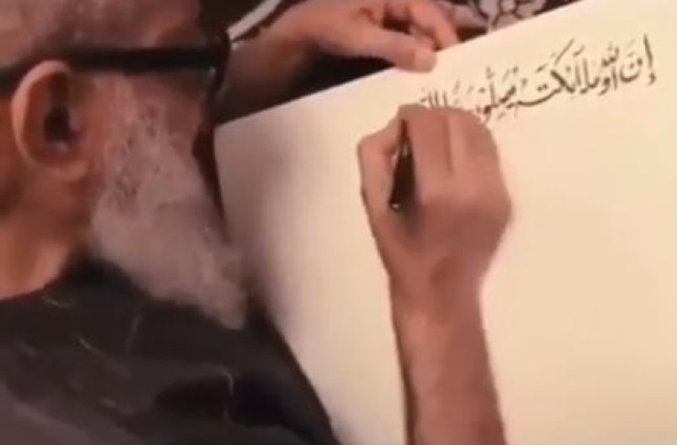 شاهد.. مُسن سعودي يدوّن إحدى آيات القرآن بخط بديع