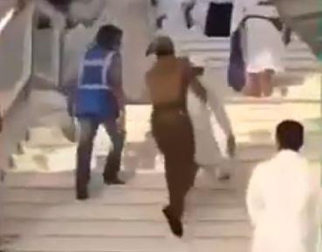 رجل أمن يحمل مسناً معاقاً لمساعدته على صعود الدرج بالمسجد الحرام (فيديو)