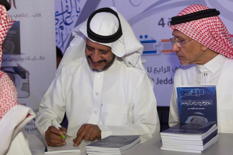 الثبيتي خلال توقيعه كتابه : الإعلام خط الدفاع الأول عن الوطن ولنكن باقلامنا السد المنيع