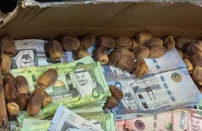 بالصور.. إحباط تهريب 1.65 مليون ريال داخل كراتين تمر وملابس في مطار المدينة