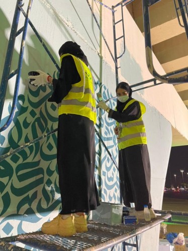 60 متطوع ومتطوعة من جمعية العمل التطوعي يشاركون جدارية الخط العربي بتبوك