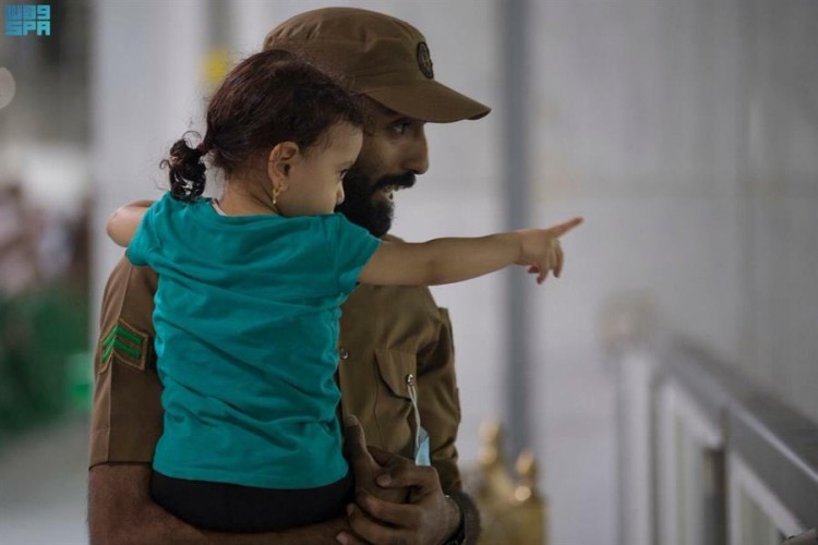 صور لطيفة لجندي وطفلة في رحاب بيت الله الحرام