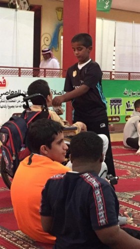 “طالبٌ يُعين زميله ‘السليم “برشفاتٍ من العصير،مُجسدًّا التكامل التعليمي في أبهى حُلله”