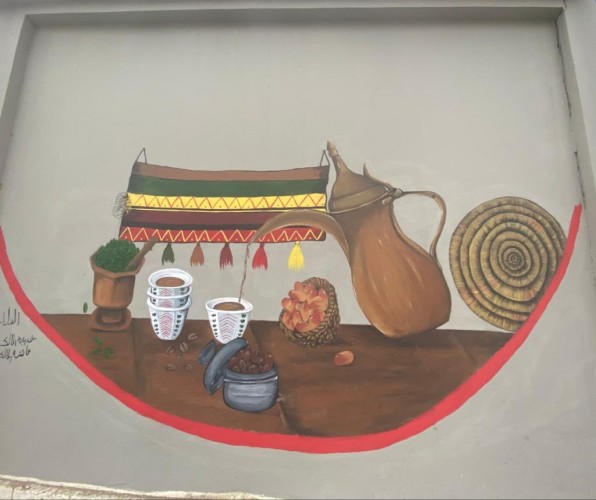 فريق كلمات وألوان يبدع في رسم جدارية مهرجان البن